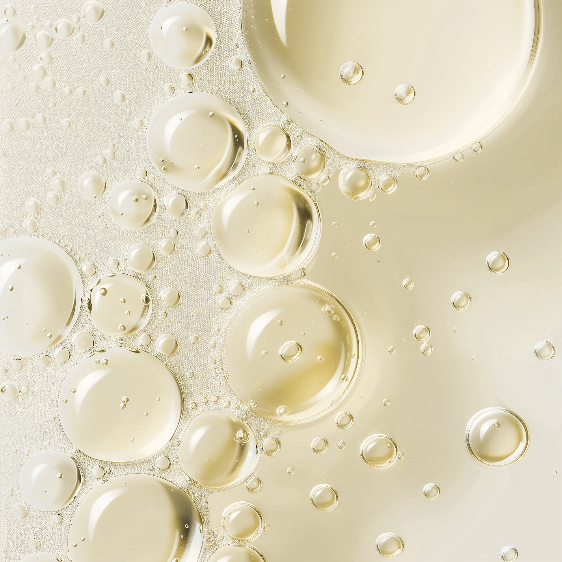 Glam Labs Hair Growth Super Serum close up of golden oil droplets in lightweight clear serum texture